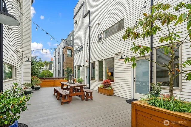 a view of a brick house with large windows and a table and chairs