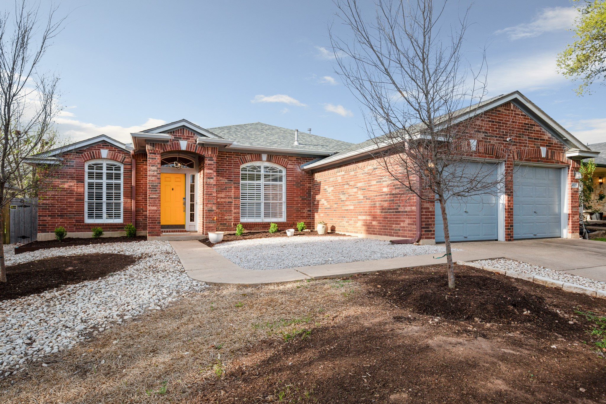 View of front of property featuring brick siding, concrete driveway, an attached garage, and roof with shingles