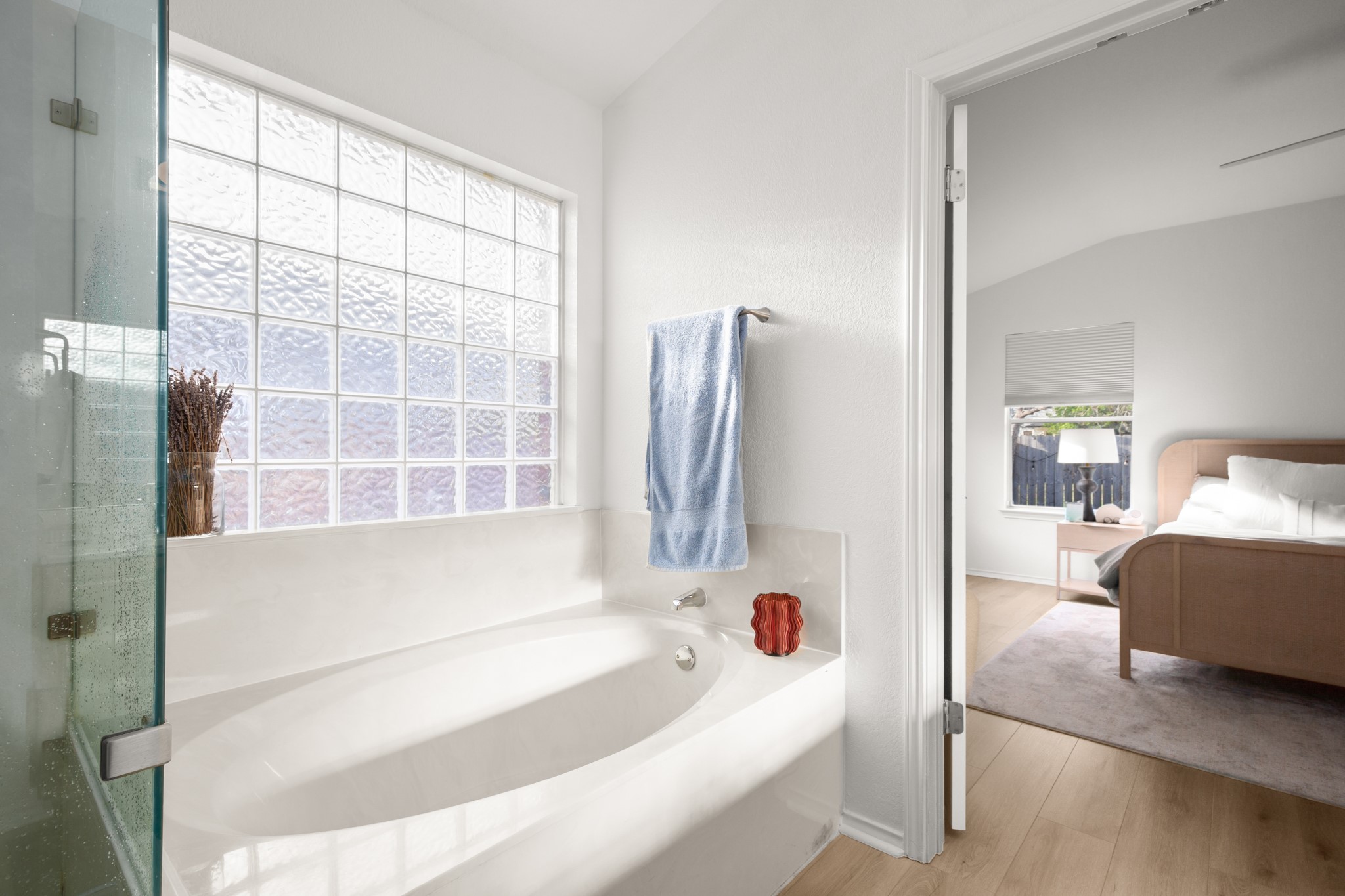 4523 Ramies Run Austin, TX 78749 - Photo 19 of 30 Ensuite bathroom featuring lofted ceiling, a bath, light wood-type flooring, and a shower stall