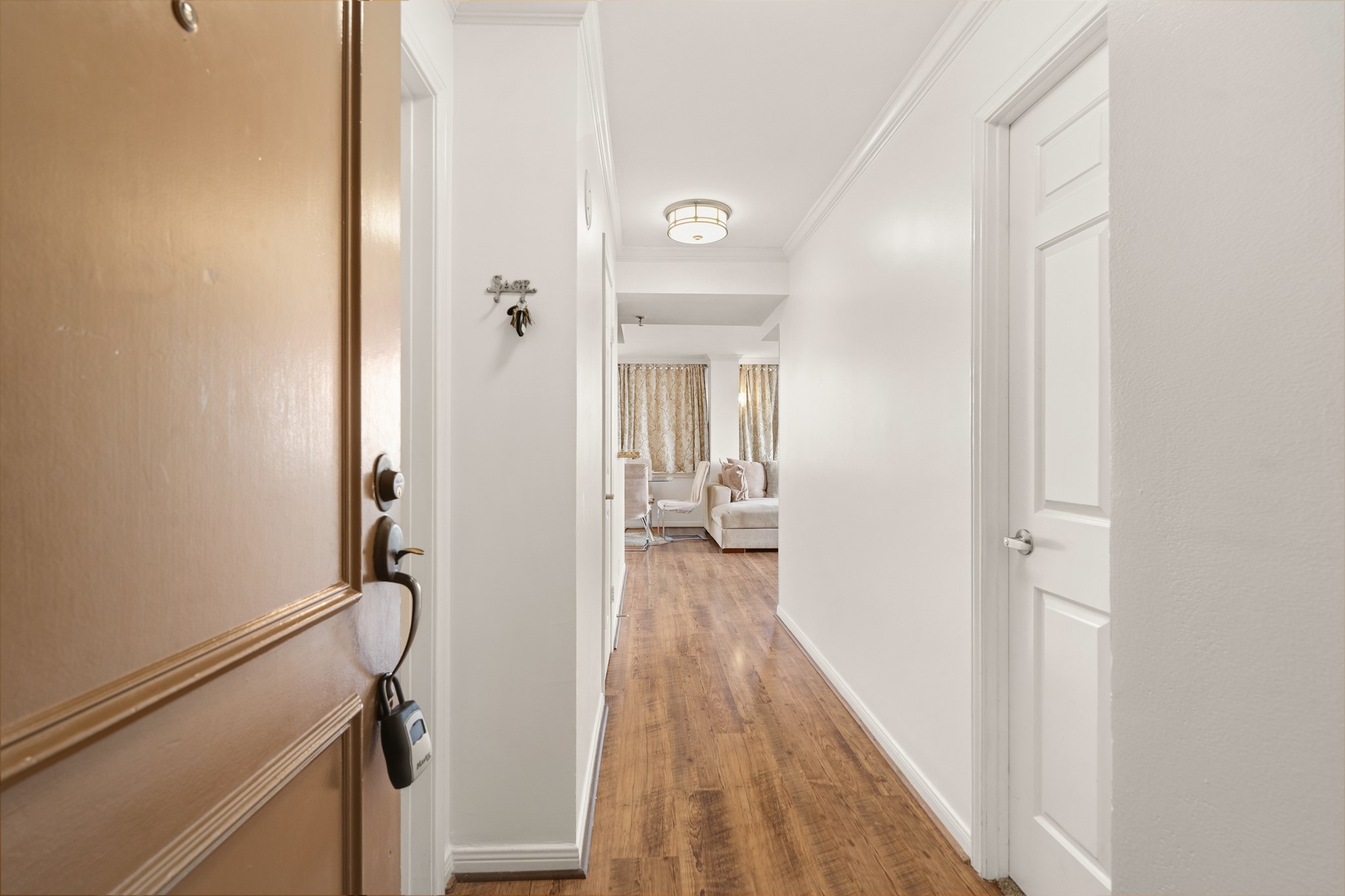 3525 Sage Road, Unit 1204 Houston, TX 77056 - Photo 2 of 25 Interior hallway connecting the living areas to the bedrooms, featuring wood-style flooring.