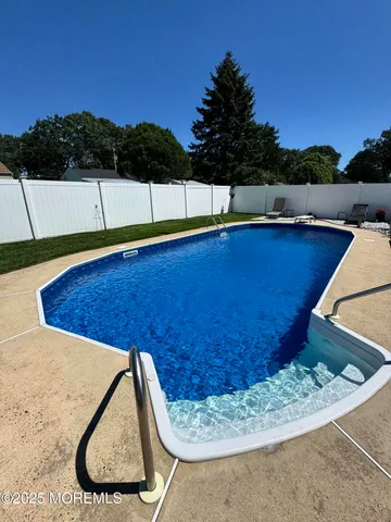a view of water pool with a chair and table in the back