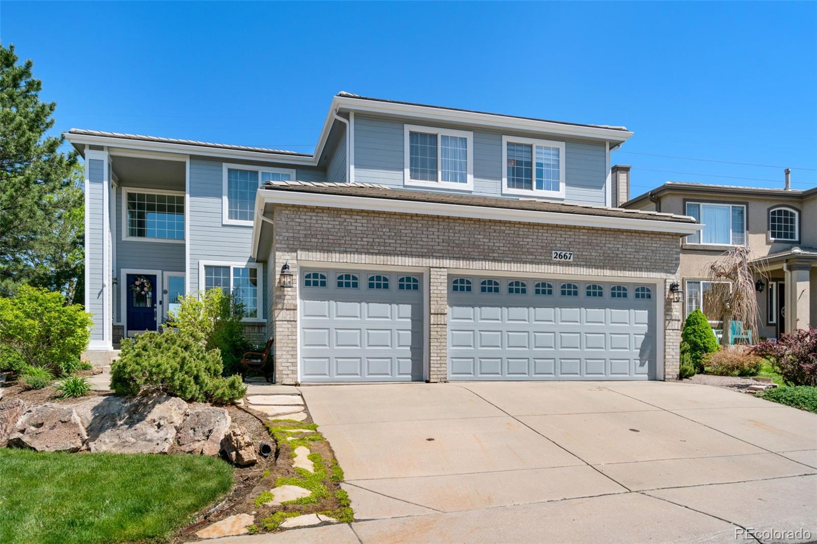 2667 West Bitterroot Place Highlands Ranch, CO 80129 - Photo 1 of 40 a front view of a house with a yard and garage