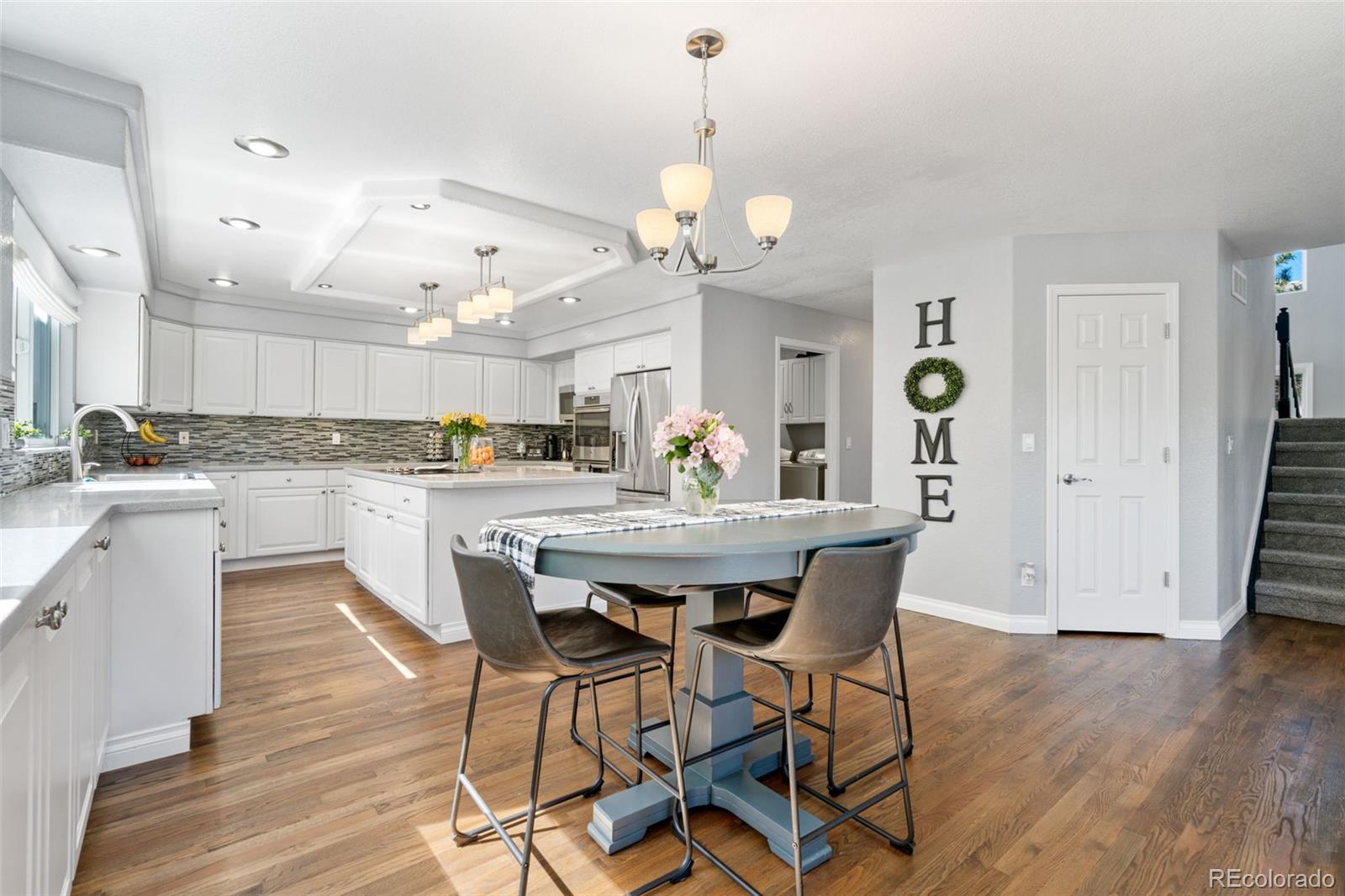 2667 West Bitterroot Place Highlands Ranch, CO 80129 - Photo 12 of 40 a view of a dining room with furniture a chandelier and wooden floor