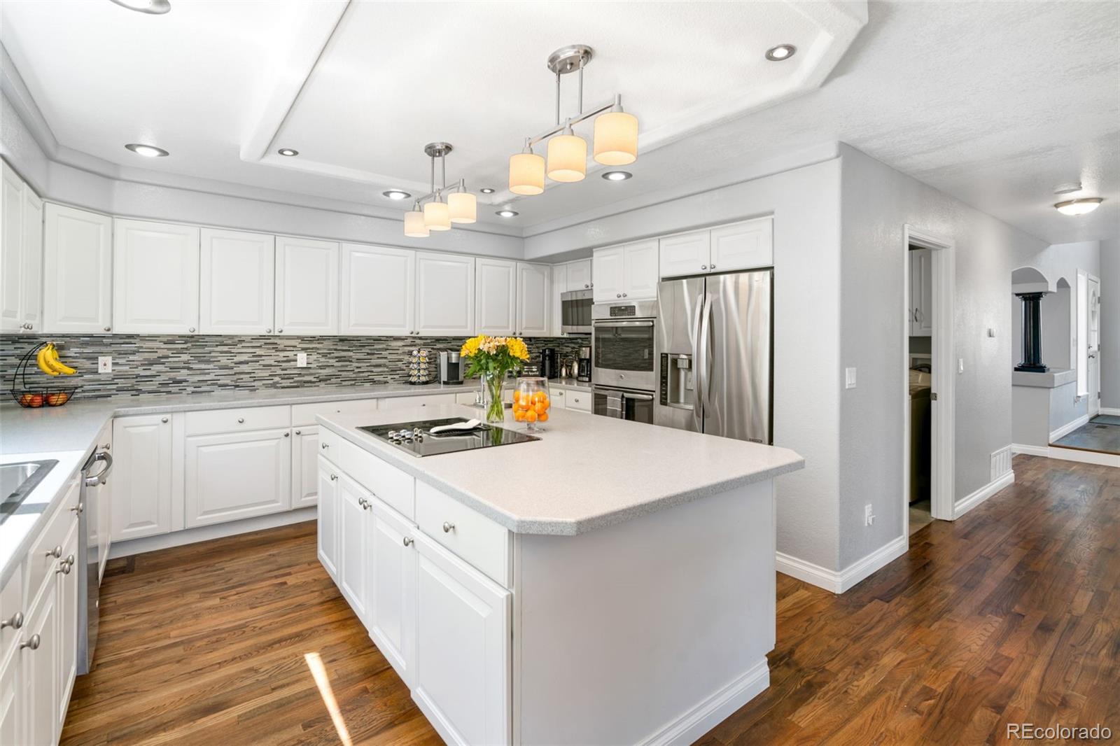 2667 West Bitterroot Place Highlands Ranch, CO 80129 - Photo 14 of 40 a kitchen that has a lot of white cabinets and stainless steel appliances