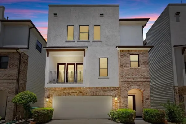 a front view of a house with plants