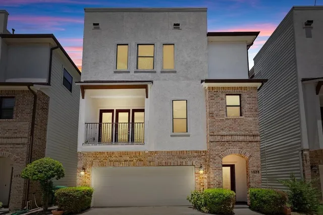 a front view of a house with plants