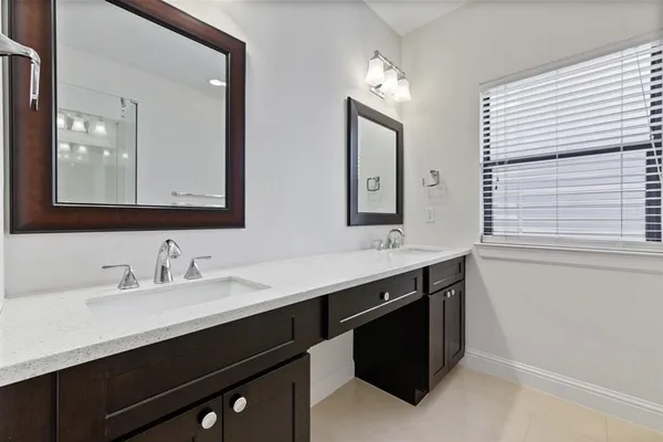 a bathroom with double sink and two mirror