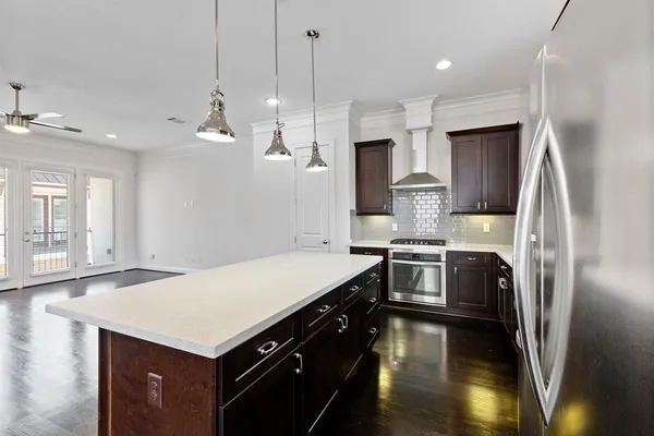 a kitchen with kitchen island a sink stainless steel appliances and cabinets