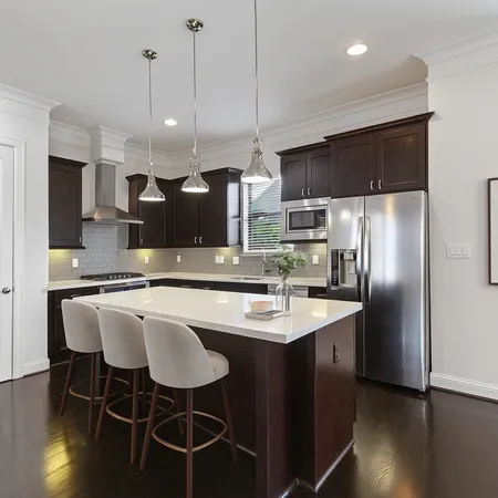 a kitchen with stainless steel appliances granite countertop a sink a stove a refrigerator and chairs