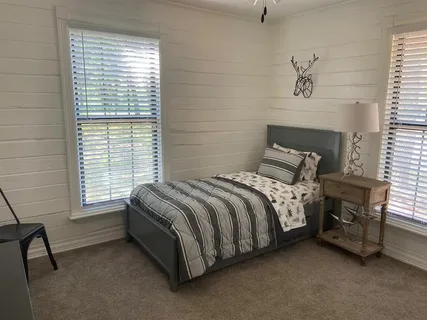 a bed sitting in a bedroom next to a window