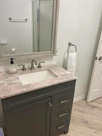 a bathroom with a granite countertop sink and a mirror