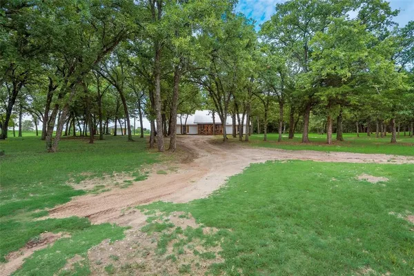a backyard of a house with lots of green space and trees all around