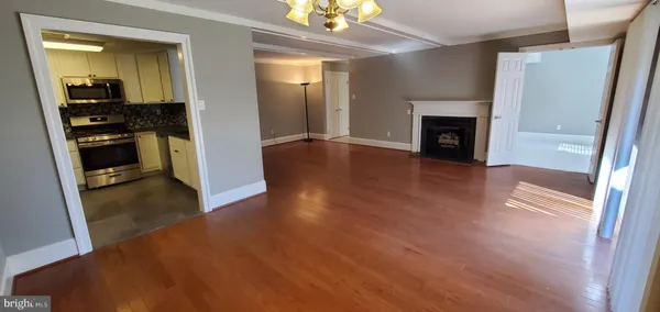 a view of a hallway with wooden floor and a fireplace