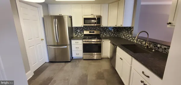 a kitchen with a refrigerator stove and sink