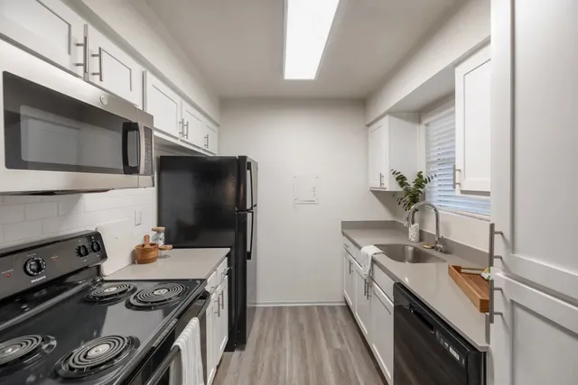 a kitchen with a sink stove and microwave