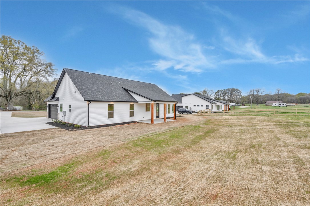 4554 Flat Rock Road Iva, SC 29655 - Photo 32 of 32 A newly constructed residence showcasing crisp white siding and a covered patio, nestled in a generous landscape.