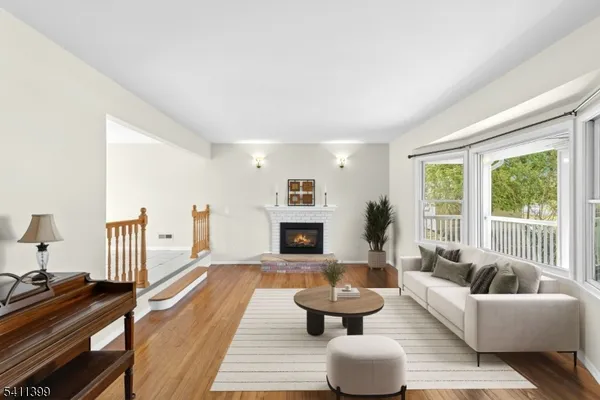 a view of a livingroom with wooden floor fireplace and a window
