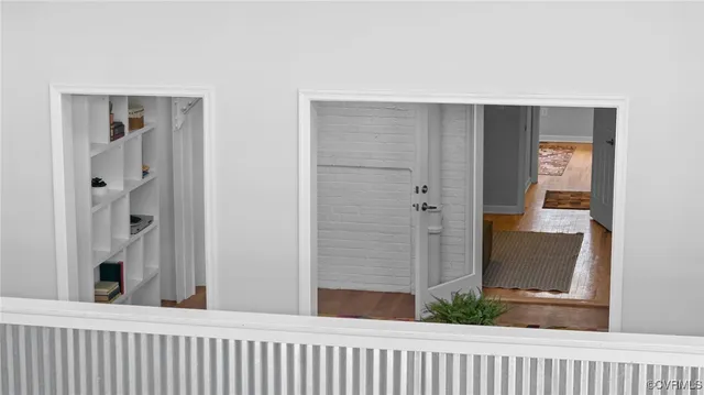 a view of a hallway with wooden floor and a living room