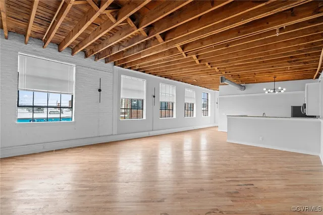 a view of empty room with wooden floor