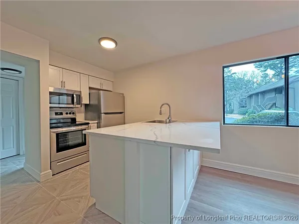 a kitchen with stainless steel appliances a white stove top oven and a refrigerator
