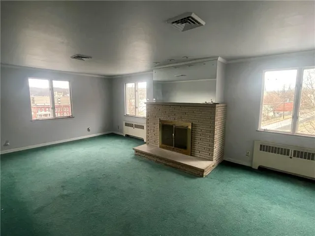 an empty room with a fireplace and window