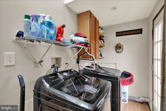 a utility room with dryer washer and a wooden floor