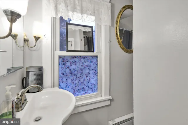 a bathroom with a sink a mirror and shower