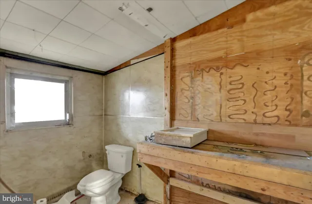 a bathroom with a granite countertop sink a toilet and shower
