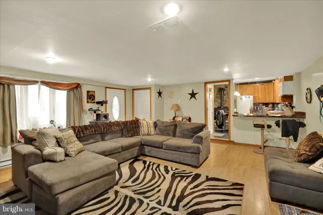 a living room with furniture wooden floor and a large window
