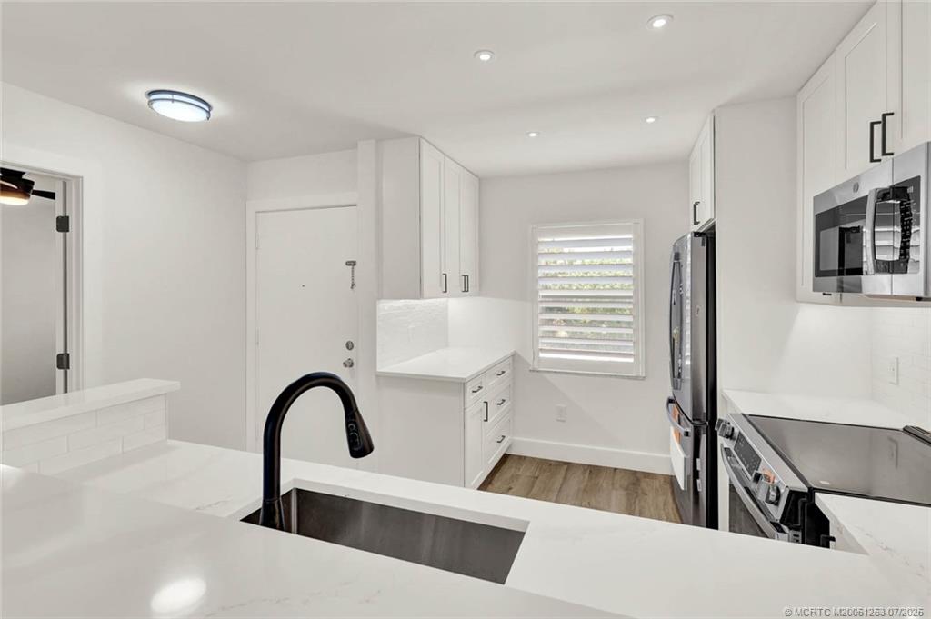 1950 Southwest Palm City Road, Unit 3201 Stuart, FL 34994 - Photo 12 of 51 a view of a kitchen counter space with a sink and living room
