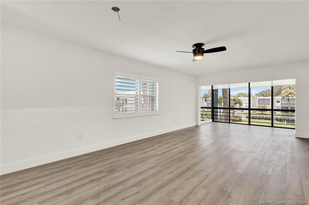 1950 Southwest Palm City Road, Unit 3201 Stuart, FL 34994 - Photo 13 of 51 wooden floor in an empty room with a window