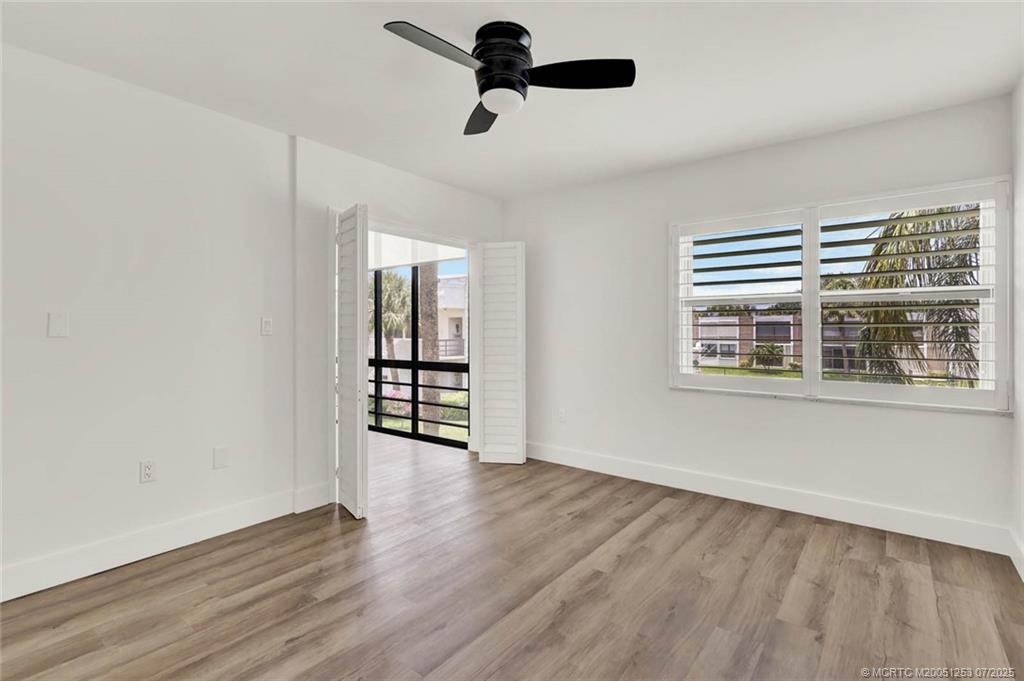 1950 Southwest Palm City Road, Unit 3201 Stuart, FL 34994 - Photo 23 of 51 a view of an empty room with wooden floor and a window