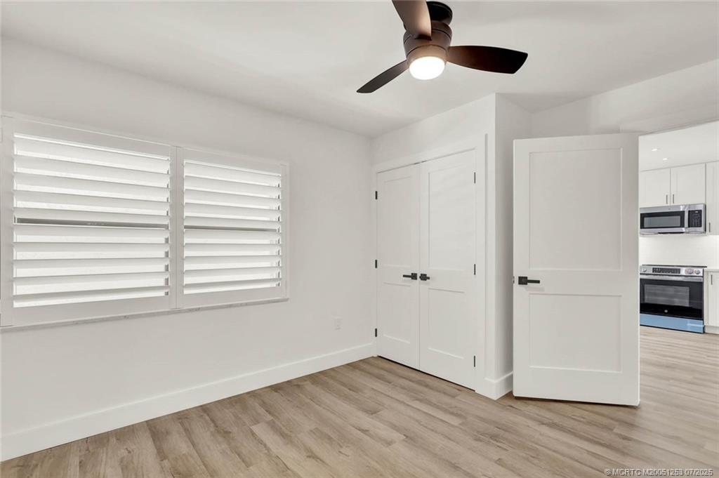 1950 Southwest Palm City Road, Unit 3201 Stuart, FL 34994 - Photo 31 of 51 a view of empty room with wooden floor and fan