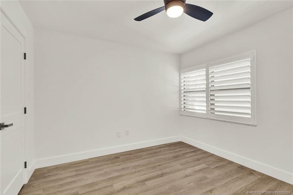 1950 Southwest Palm City Road, Unit 3201 Stuart, FL 34994 - Photo 33 of 51 an empty room with wooden floor cabinet and windows