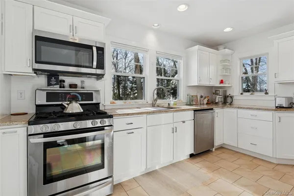 a kitchen with white cabinets stainless steel appliances and sink