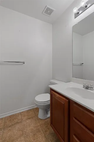 a bathroom with a granite countertop toilet and a sink