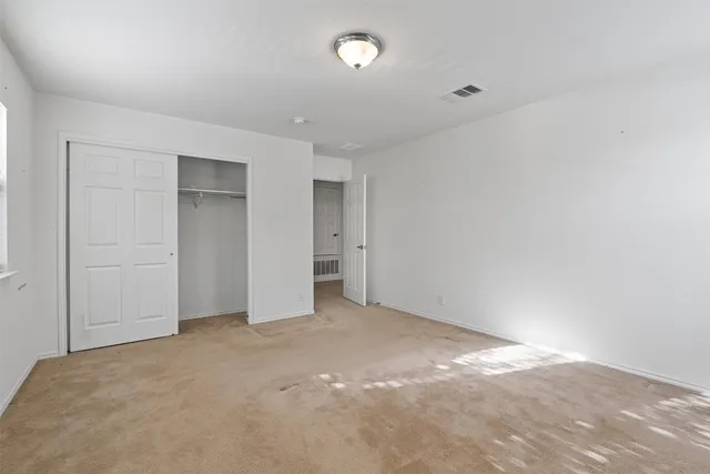 an empty room with closet area and bathroom