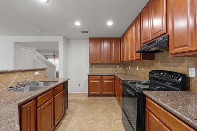 a kitchen with granite countertop stainless steel appliances and wooden cabinets