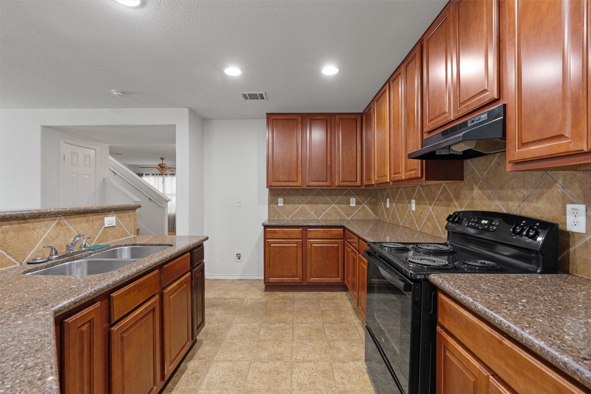 5700 Welsh Way Del Valle, TX 78617 - Photo 9 of 39 a kitchen with granite countertop stainless steel appliances and wooden cabinets