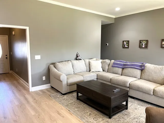 a living room with a couch and a view of kitchen