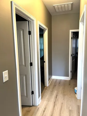 a view of a hallway with wooden floor and closet