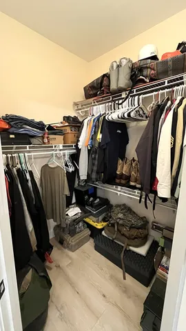 a view of walk in closet with clothes and shoes