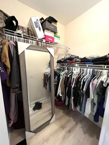a view of walk in closet with clothes and shoes
