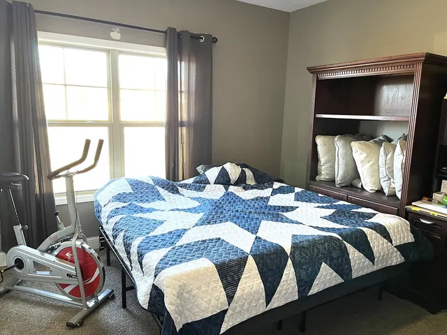 a bed sitting in a bedroom next to a window