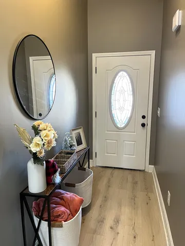 a front view of a house with wooden floor a glass table and a vase