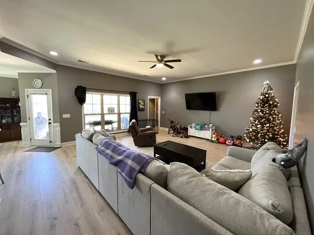 a living room with furniture or chandelier and a wooden floor