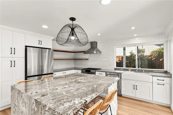 a kitchen with stainless steel appliances granite countertop a sink stove and refrigerator