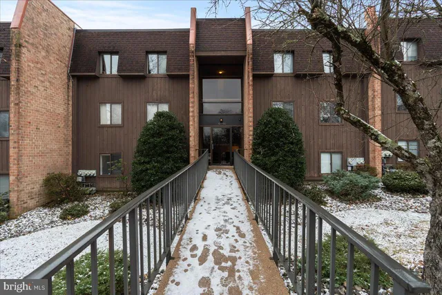 a view of a house with brick wall and a large tree
