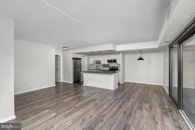 a kitchen with granite countertop a sink a counter top space stainless steel appliances and cabinets