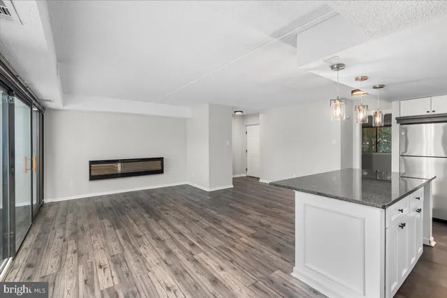 a view of kitchen living room with wooden floor and electronic appliances